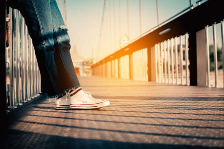hipster tourist traveler feet on bridge background, resting lifestyle on vacation.の写真素材