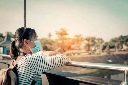 The new normal a girl wearing a mask during travel and public place.の写真素材