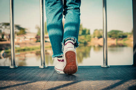 hipster tourist traveler feet on bridge background, resting lifestyle on vacation.の写真素材