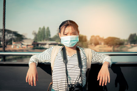 The new normal a girl wearing a mask during travel and public place.の写真素材