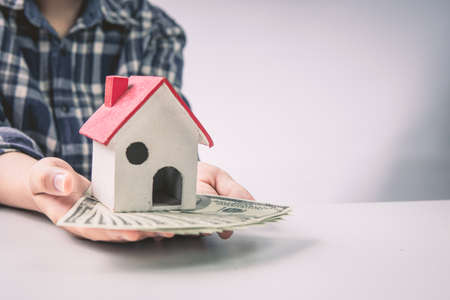Human hand protects wood house model, the residential crisis in the  situation.の写真素材