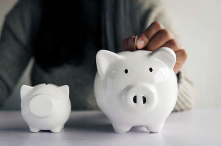 Woman hand and white piggy bank to saving money concept .budget, financial.の写真素材