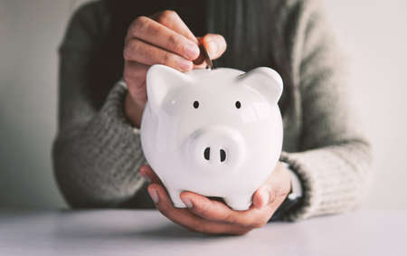 Woman hand and white piggy bank to saving money concept .budget, financial.の写真素材