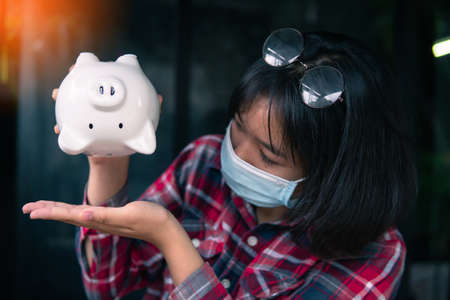 Woman hand holding white piggy bank to saving money concept.budget, financial.の写真素材