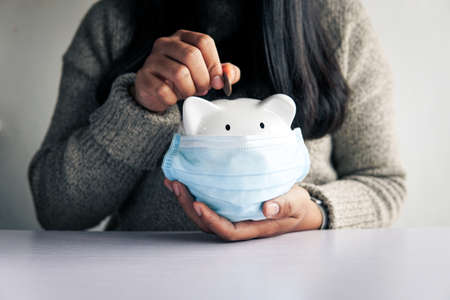 Woman hand and white piggy bank to saving money concept .budget, financial.の写真素材