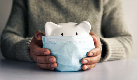 Woman hand and white piggy bank to saving money concept .budget, financial.の写真素材