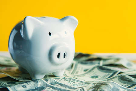 White piggy bank on the table and yellow background save money concept.の写真素材