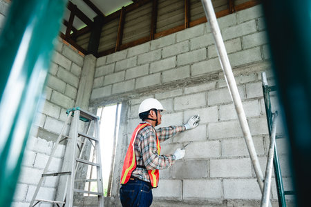 An engineer inspects construction operations and assesses the structural integrity of a house. This...