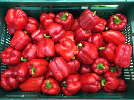 Many sweet peppers in the basket for saleの写真素材