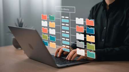 Businessman working on laptop computer with folder icons on screen, closeupの素材