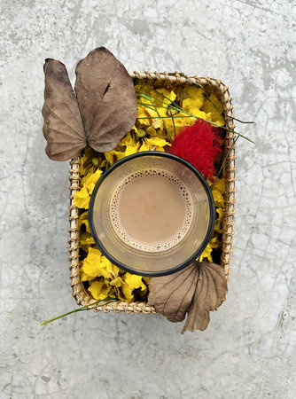 Cup of coffee and autumn flowers in a basket backgroundの写真素材