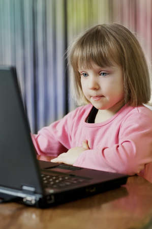 Little girl playng with PCの写真素材