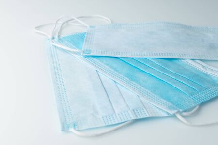 Three medical masks seen from the right and the reverse side isolated on white background.Concept...