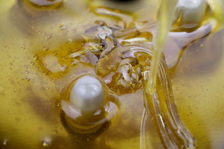 Texture of sweet stretching honey. Close-up and macro of honey bubbles.の写真素材