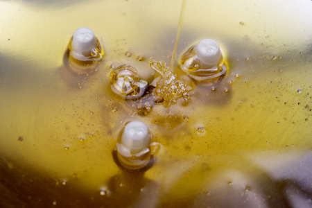 Texture of sweet stretching honey. Close-up and macro of honey bubbles.