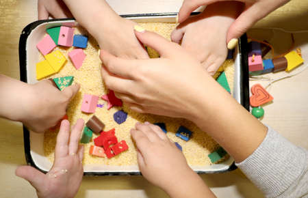 Children playing with kinetic sand, croup and designer in preschool. The development of fine motor...