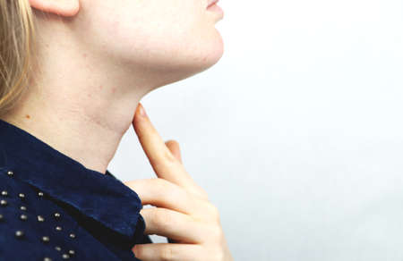 Thyroid gland. Closeup portrait of cute sick young blonde woman in white top having sore throat,...