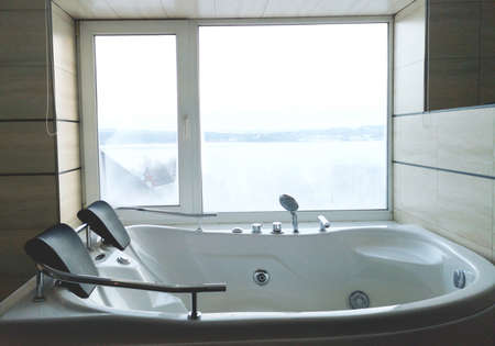 Hot tub in the hotel room. Beautiful view, relaxation and relaxation. Photo through the reflection of the mirrorの写真素材