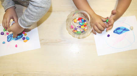 Kids group making arts and crafts in kindergarten. Children spending time in day care centre with...