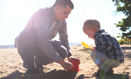 Father and son on the beach in springの写真素材