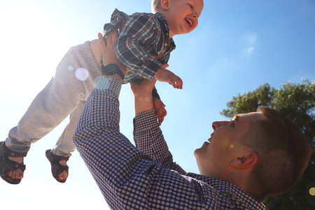 happy excited father and son playing on summer beach, enjoy life