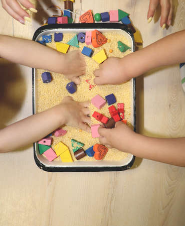 Children playing with kinetic sand, croup and designer in preschool. The development of fine motor...
