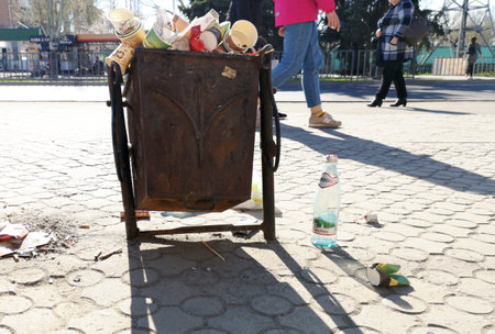 Nikopol, Ukraine, May 20, 2019: a crowded trash can on the Ukrainian street, with garbage on paving slabs.のeditorial素材