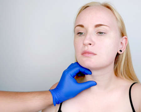 A cosmetologist prepares the patient for surgery: contour plastics of the neck, mesotherapy or...