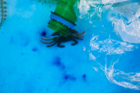 Small crab entangled in a plastic bag. Plastic pollution of the oceans. Ecology and environment...