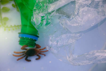 Small crab entangled in a plastic bag. Plastic pollution of the oceans. Ecology and environment...