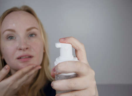The girl washes and cleanses the skin with facial foam. Cleanser for oily, dry and combination skin....