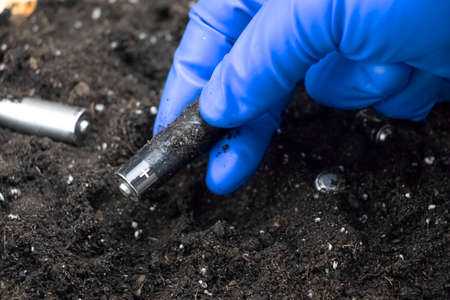 Used batteries in the ground. Hazardous waste polluting the environment. The concept of...
