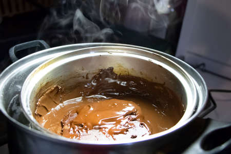 Melted chocolate in a pan under a water bath. Making hot chocolate at home in your own kitchenの写真素材