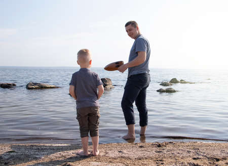 Dad and son launch a ship on the radio. Father shows the boy how to play with the boat on the remote...