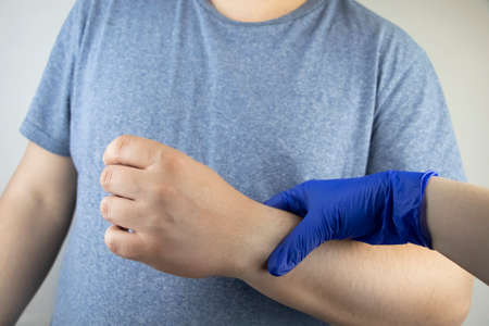 A manâ€™s wrist hurts. Traumatologist examines a hand. Wrist pain as a sign of tunnel syndrome...