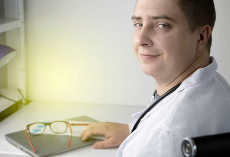 Workplace of a doctor. Male therapist works at a computer. The concept of modern medicine and technology used by medical professionalsの写真素材