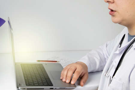 Workplace of a doctor. Male therapist works at a computer. The concept of modern medicine and technology used by medical professionalsの写真素材