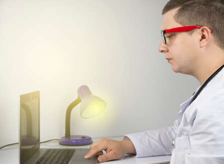 Workplace of a doctor. Male therapist works at a computer. The concept of modern medicine and...