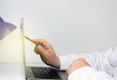 Workplace of a doctor. Male therapist works at a computer. The concept of modern medicine and technology used by medical professionalsの写真素材