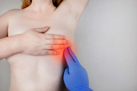 A woman suffers from chest pain. On examination by a gynecologist-mammologist. The concept of the prevention of breast diseases, cancer, mastopathy or hormonal disordersの写真素材