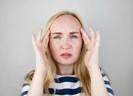 A woman suffers from headache or hypertension. The concept of treatment and prevention of migraineの写真素材