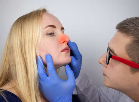 A doctor trichologist conducts a study of the hair of a blonde. Alopecia treatment. Hair loss, alopecia, itching, burning in the head, seborrhea or brittle endsの写真素材