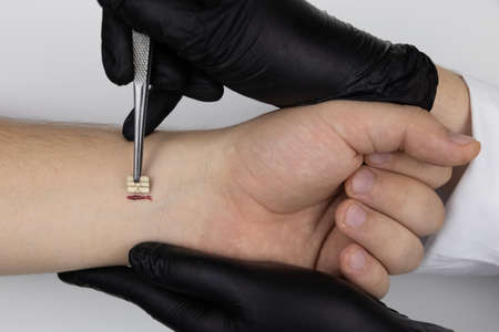 A policeman shines a flashlight on the hand of a man who has a chip implanted. The concept of...