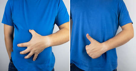 Conceptual photography. The man holds a red ball near his belly, which symbolizes bloating and flatulence. Then he brings a needle to it to burst the balloon and thus get rid of the problem.の写真素材