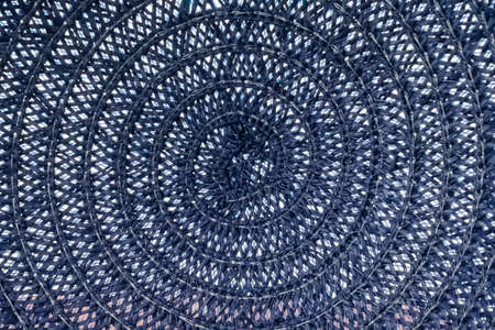 Macro texture of blue threads tied in a spiral between which there are white gaps. Close-up of...