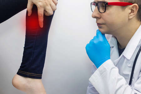 The woman suffers from pain in the calf mouse. Knee treatment concept for trauma, myositis, nerve damage or osteoarthritis. Doctor examinesの写真素材