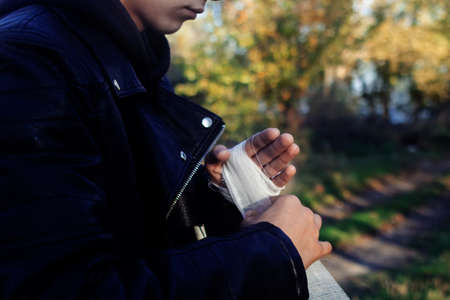 The fighter is bandaging his hands. The concept of preparation for a fight, sports competition, boxing and kickboxing. A man in a leather jacket.の写真素材