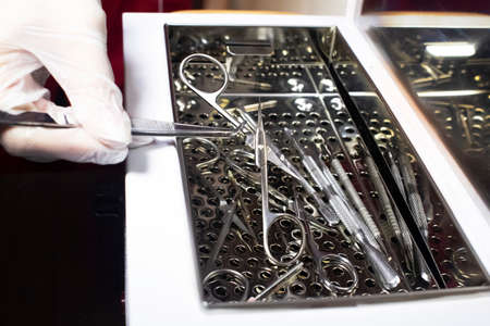 The girl takes out various metal instruments from the electronic sterilizer. Preparation for work....