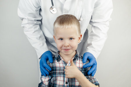 The child hugs the doctor. Examination of the boy by a pediatrician. Child protection, healthcare and medical care concept. Close-up on white backgroundの写真素材