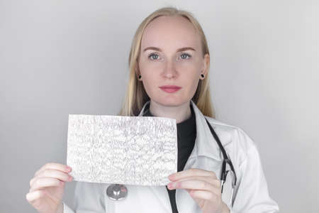 A neurologist examines an encephalogram of a patient's brain. Schedule of electroencephalograms -...